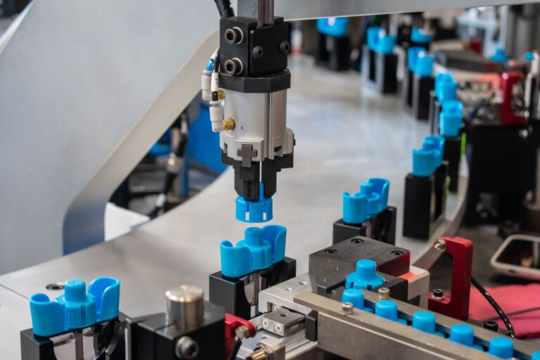 Servo-driven Pick and Place station with a blue part gripped and ready to insert onto a nested part on an indexing dial.