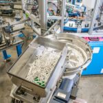 Unique parts feeding setup with a bulk hopper feeding a vibratory feeder bowl that is integrated onto an automated assembly machine.