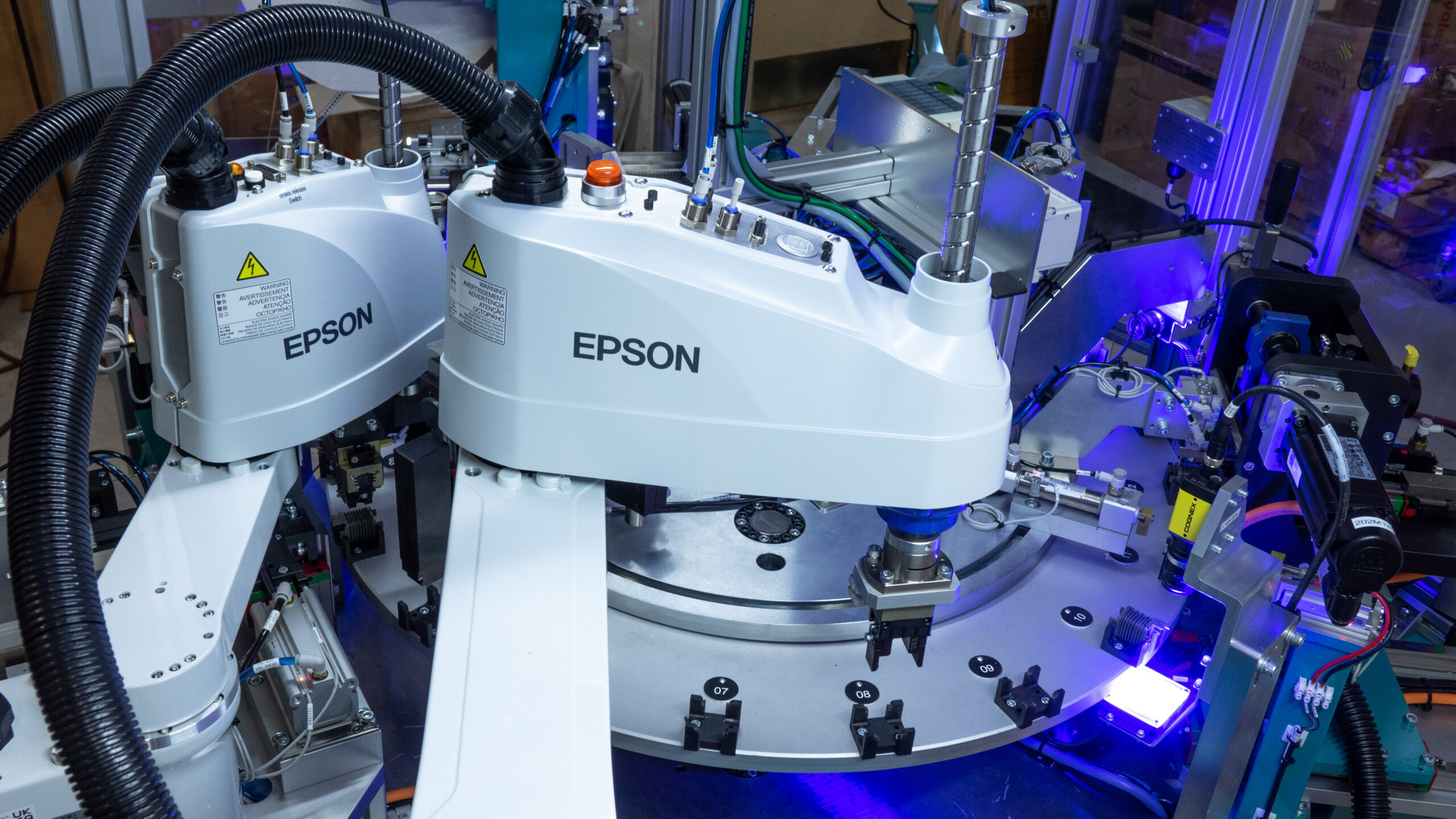 Two Epson SCARA robots integrated on an automotive part assembly machine