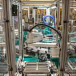 Teal and gray automated assembly machine.