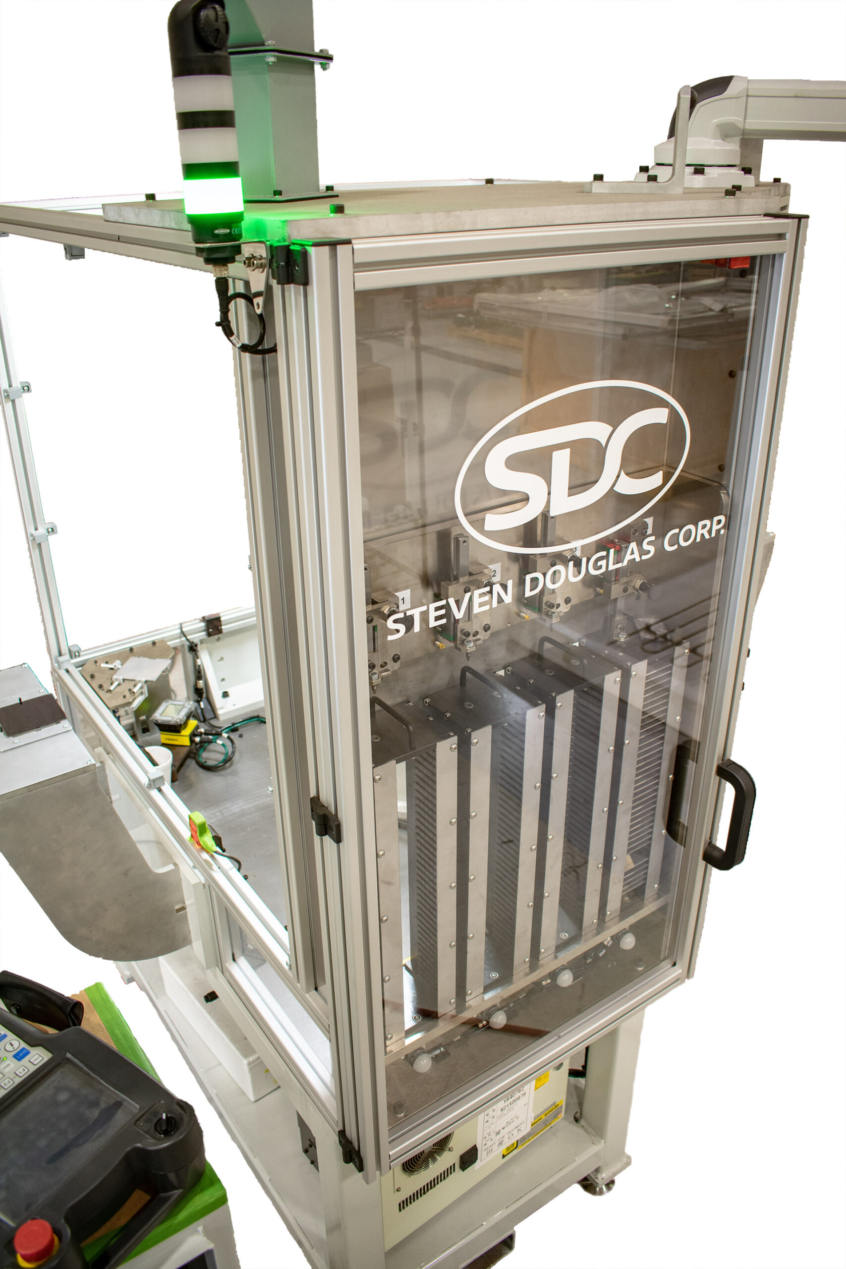 Machinery featuring a clear protective enclosure to allow viewing off of the equipment inside. A green indicator light is illuminated above the enclosure.