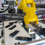 Parts supplied on a conveyor for a flex feeding application by a six-axis robot with a part loading station on the side