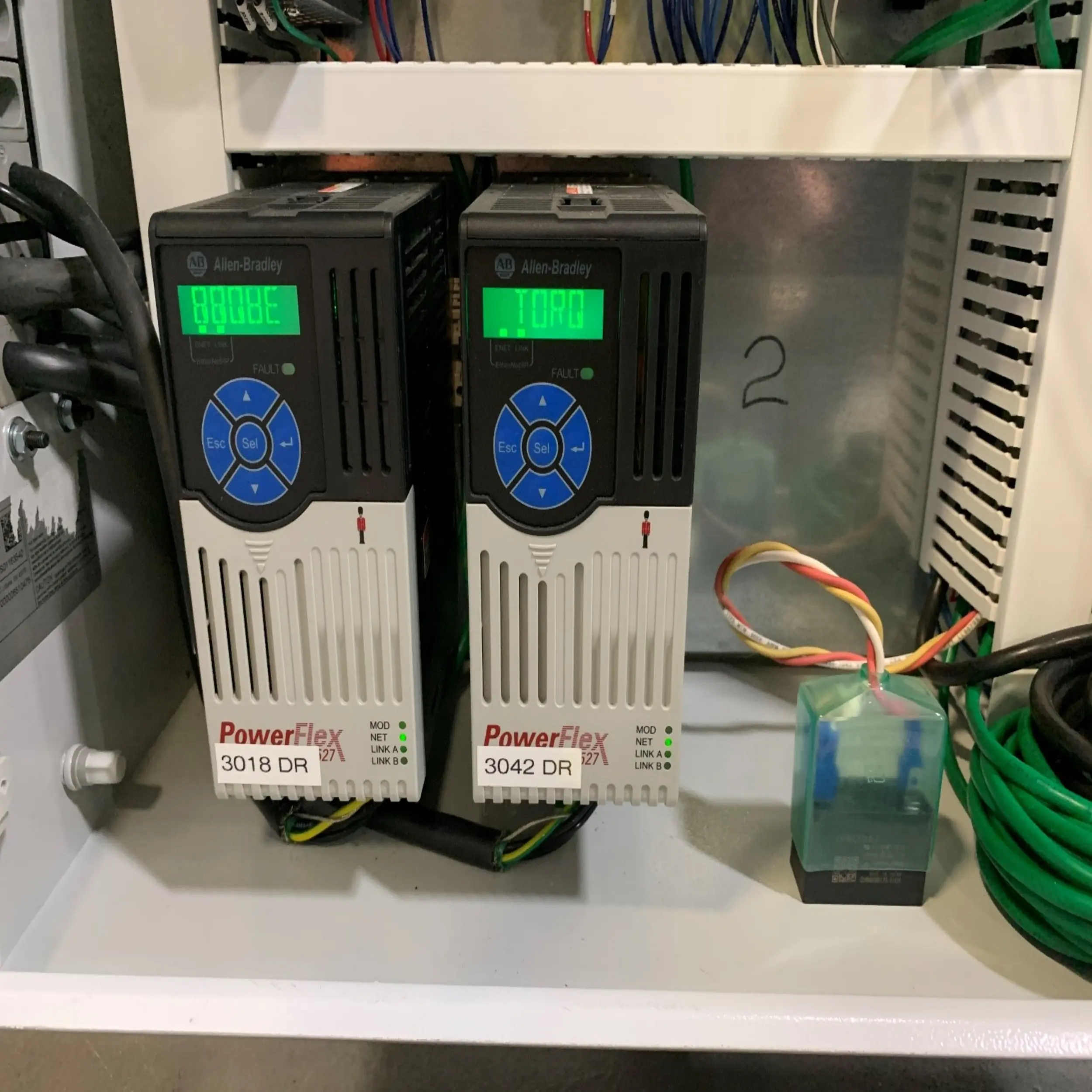 Two Allen-Bradley PowerFlex variable frequency drives inside an enclosure. One displays "8808E", the other "TORO".