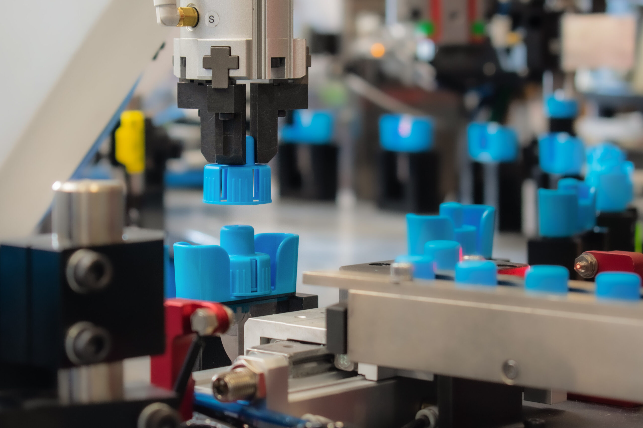 Automated system assembling blue plastic components on a high-precision manufacturing production line.