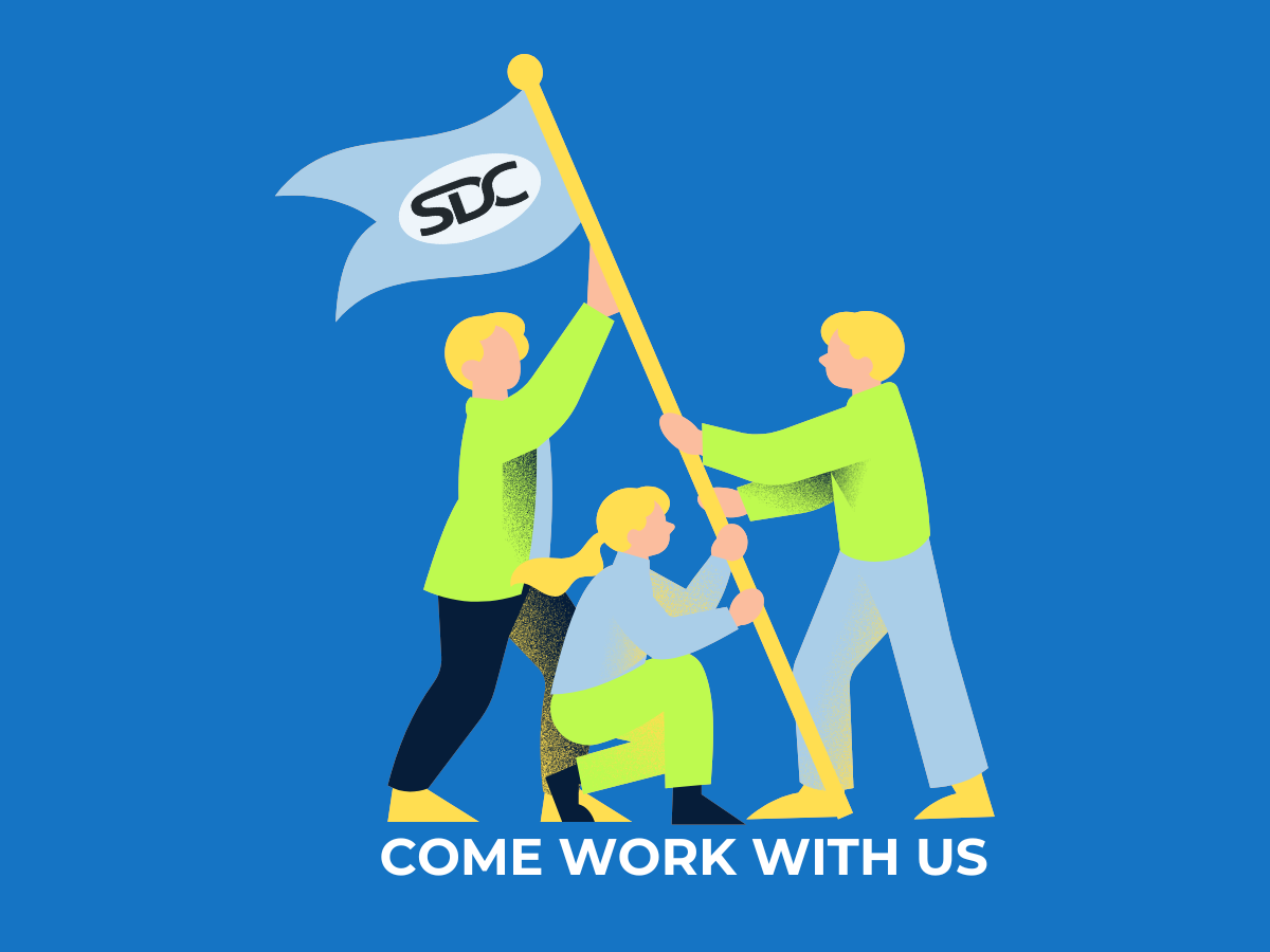 Team raising a flag with "SDC" on it. Text below reads: "COME WORK WITH US".