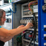 A female electrical engineer working on an electrical cabinet