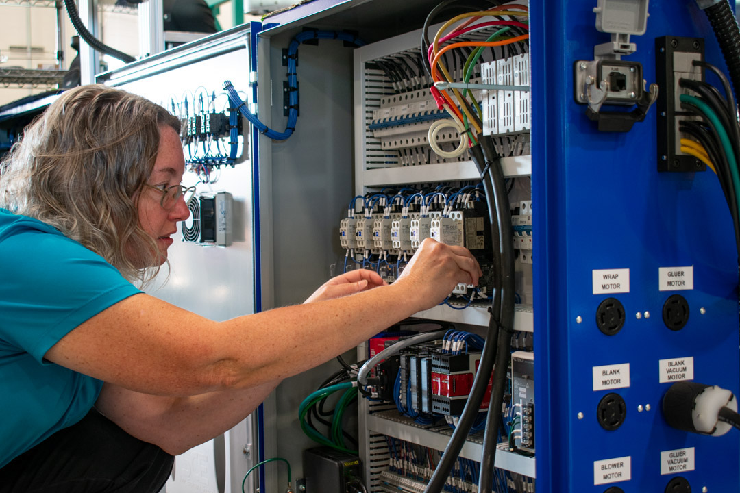 A female electrical engineer working on an electrical cabinet