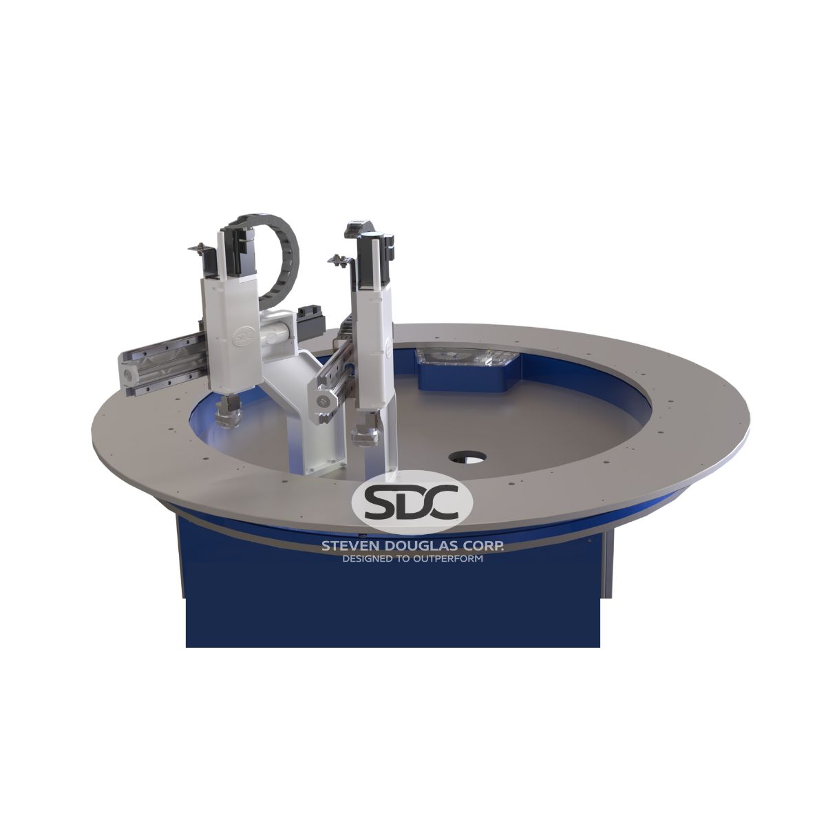 Close-up of an indexing ring machine. It features two white robotic arms mounted on a circular gray and blue rotating table with the SDC logo on the front.