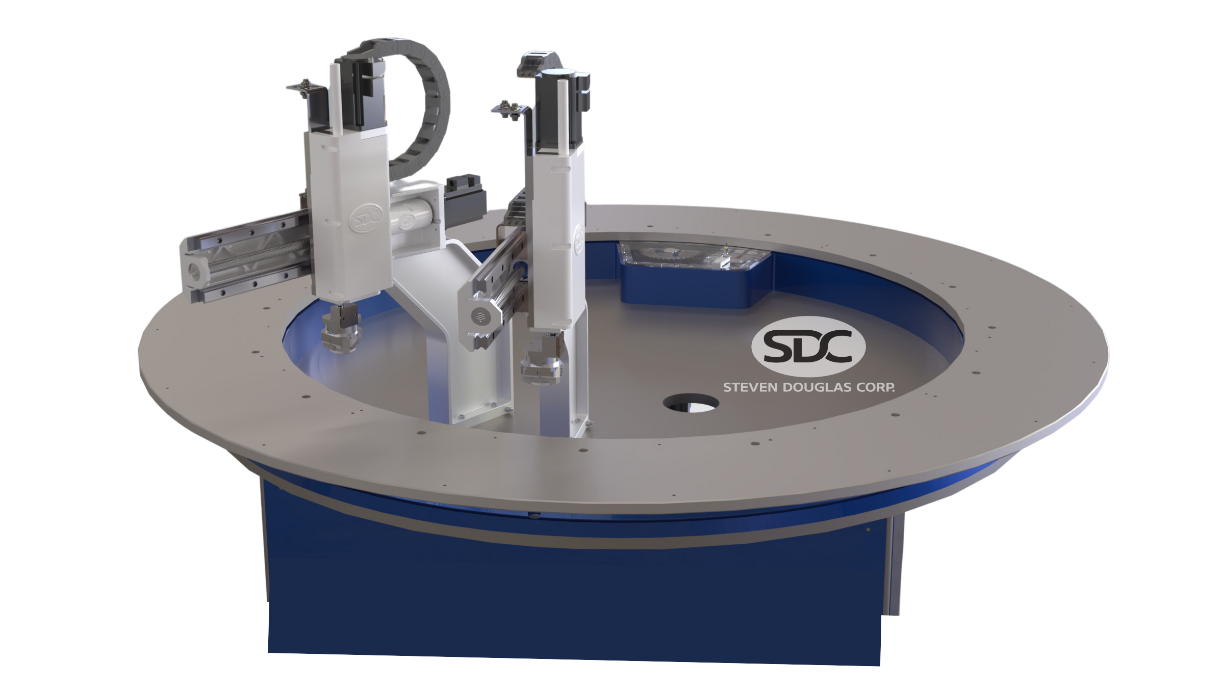 Close-up of an indexing ring machine. It features two white robotic arms mounted on a circular gray and blue rotating table with the SDC logo on the front.