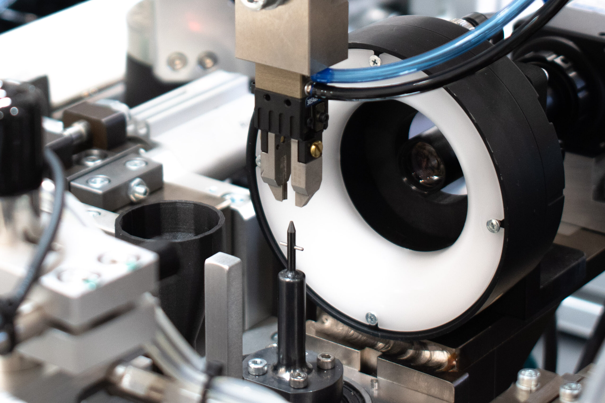 Automated robotic arm with gripper precisely positioning a small component on a manufacturing assembly line.