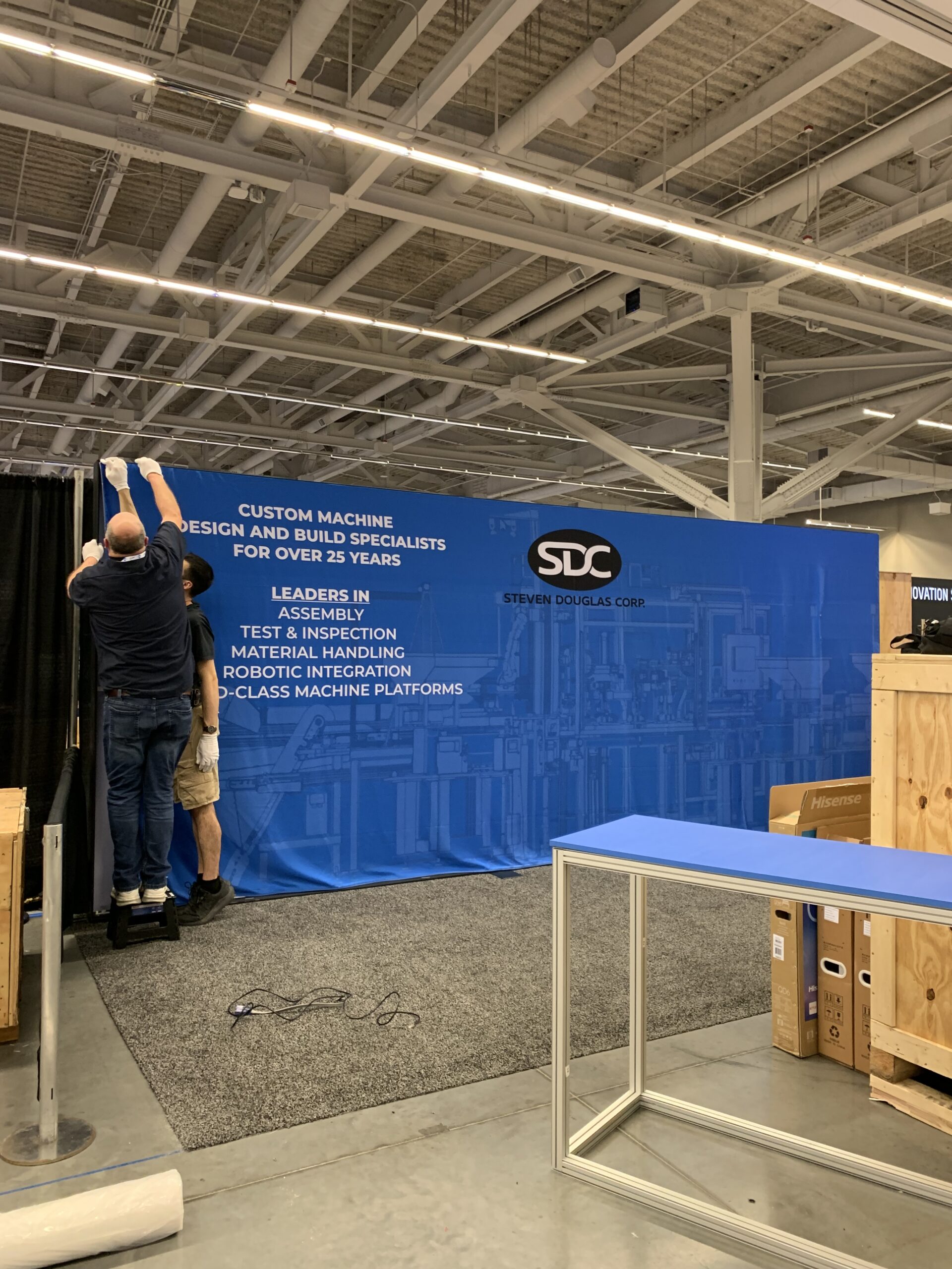 Two SDC team members setting up the 2025 PMTS booth