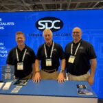 Three SDC team members posing for a picture in the SDC booth