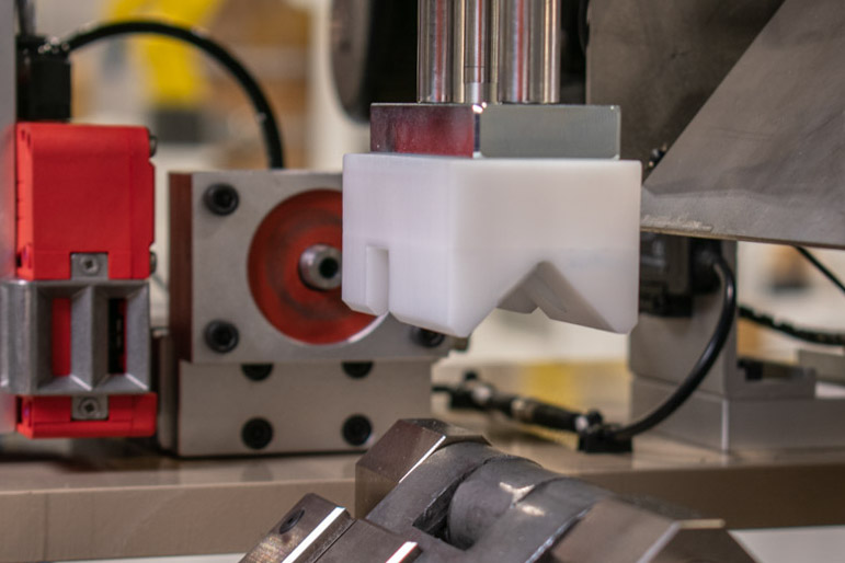 Various components are visible, including a red sensor, a gray aluminum block, and a white block with a unique, v-shaped tip.