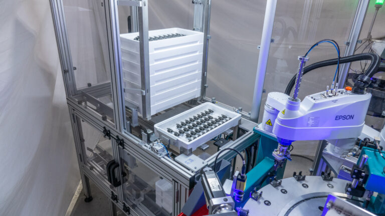 Epson robot arm assembling parts in a manufacturing setting. Automated process.