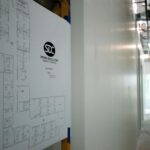 Floor plans hung on the wall that are drawn in black and white, hanging on the wall.