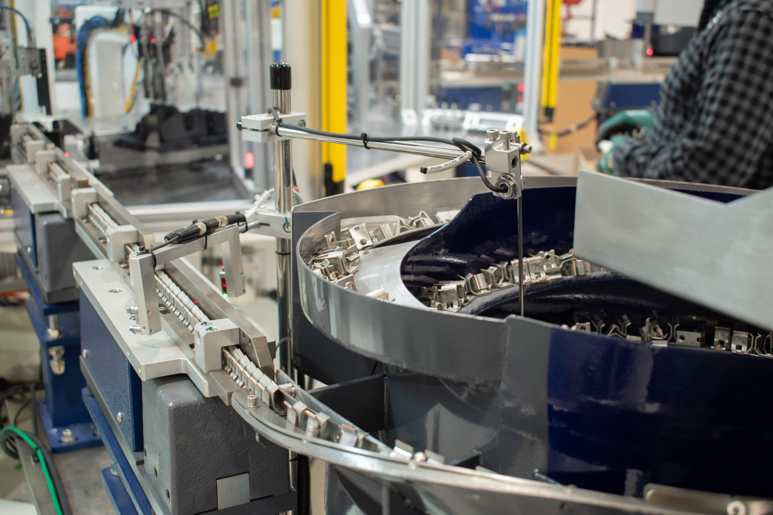 Vibratory bowl feeding parts into a switch assembly machine