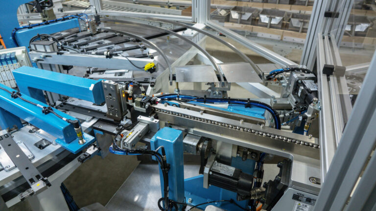 Linear inline track feeding parts to a servo-driven pick-and-place station