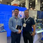 An SDC booth member posing with a Barnum rep at Automate