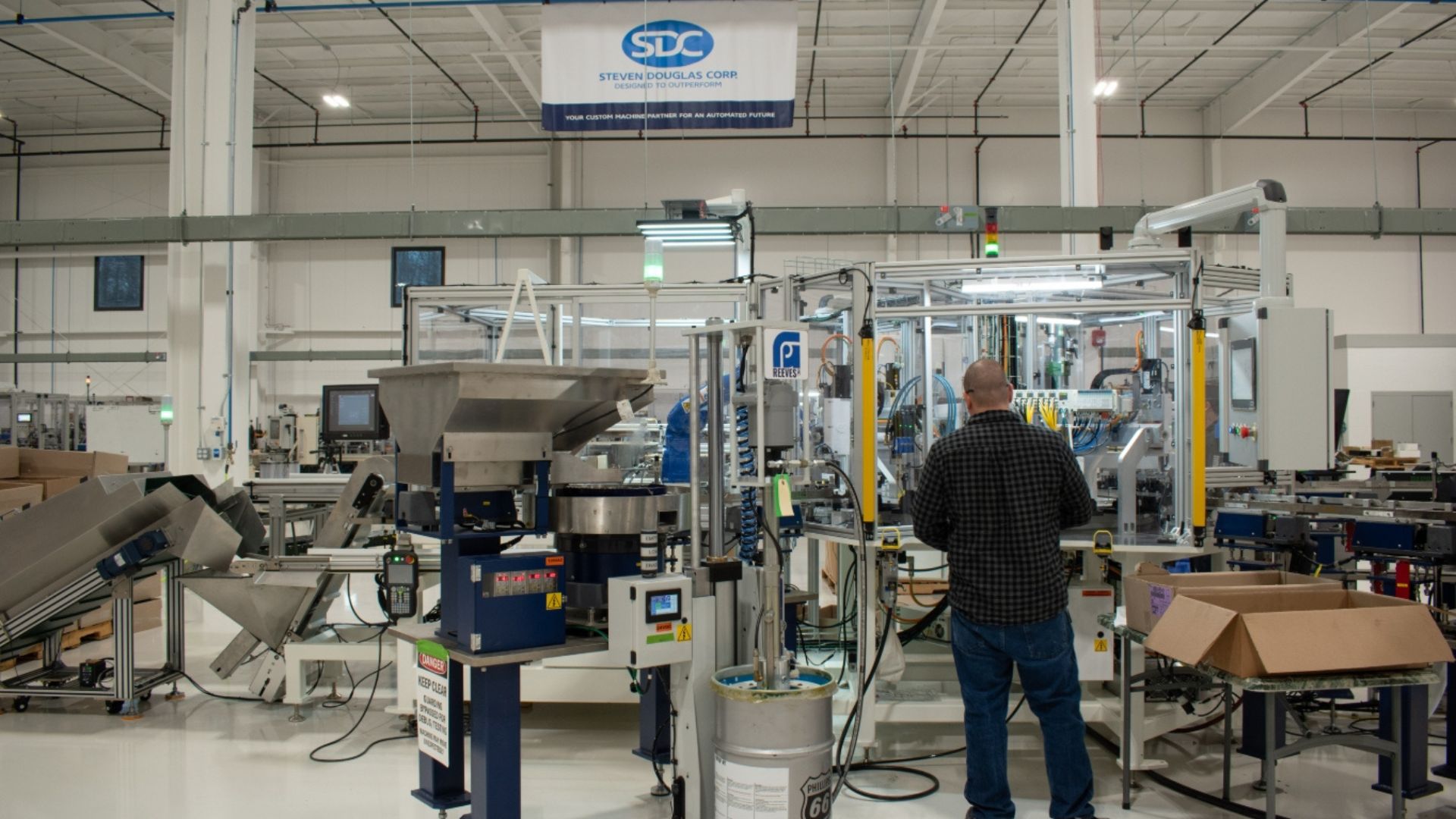 Engineer working on a machine with the SDC flag in the background.