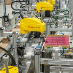 Assembly line of FANUC robots performing an automated packaging process with custom SDC technology