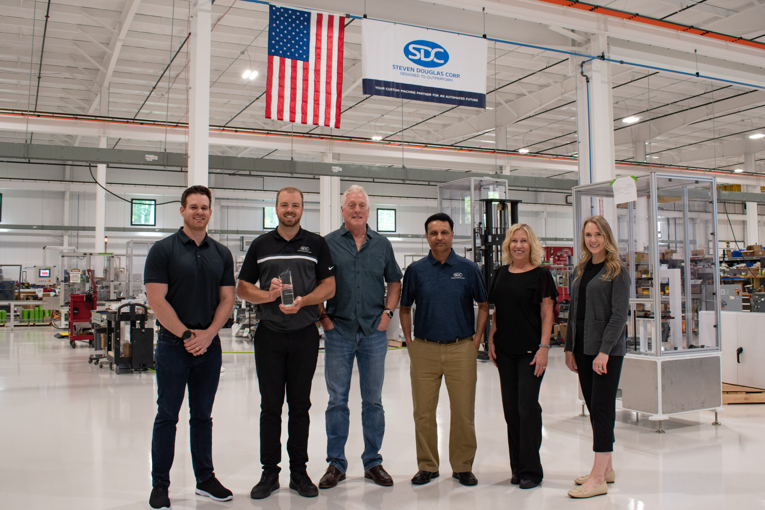 Several members of the SDC team accepting the 2024 Outstanding Sales Growth Award from FANUC