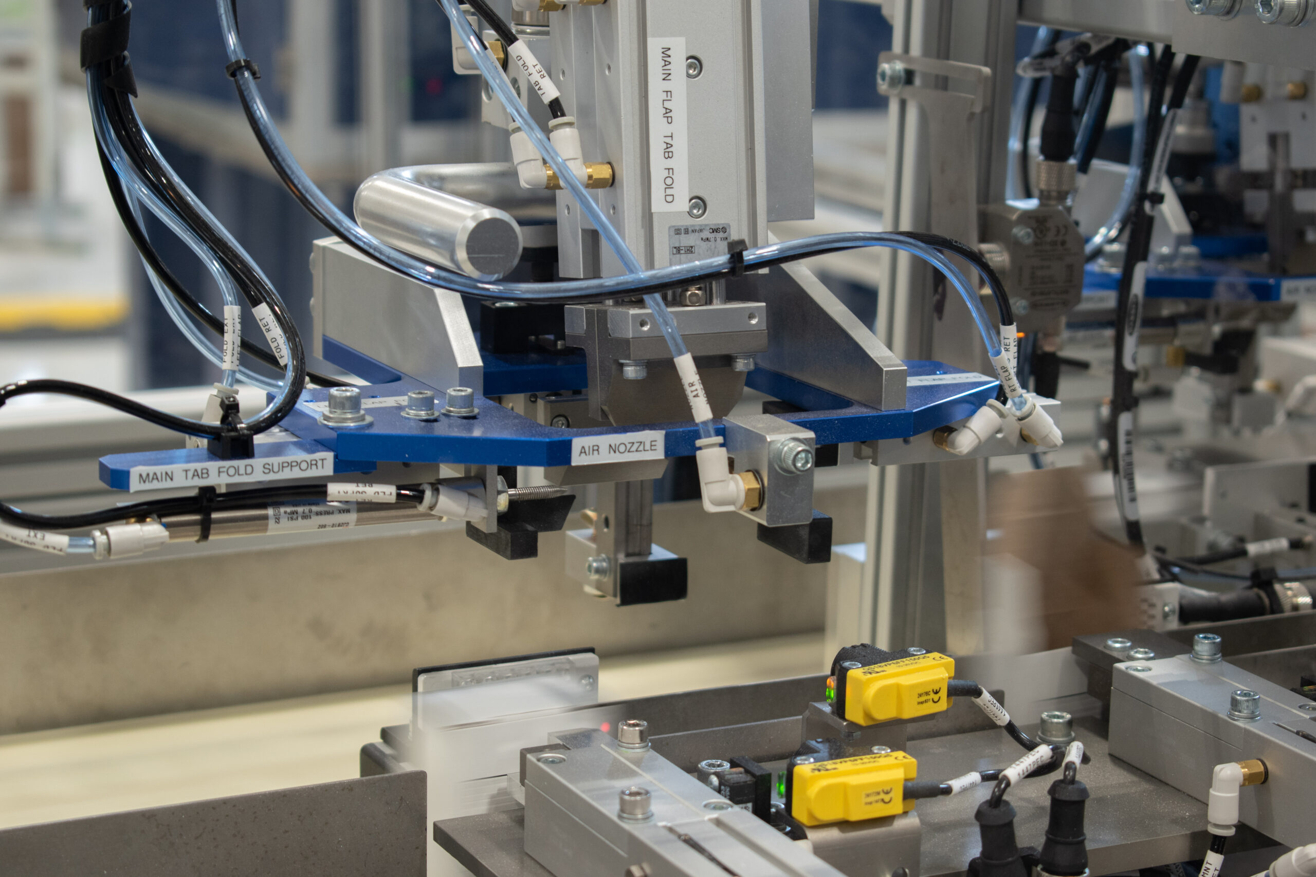 Tuck and fold top of carton closure on an industrial hose clamp packaging machine