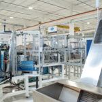 Large part hopper connected to a centrifugal feeder on an automated cartoning machine