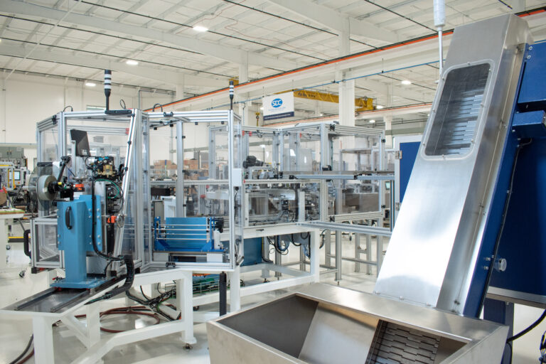 Large part hopper connected to a centrifugal feeder on an automated cartoning machine