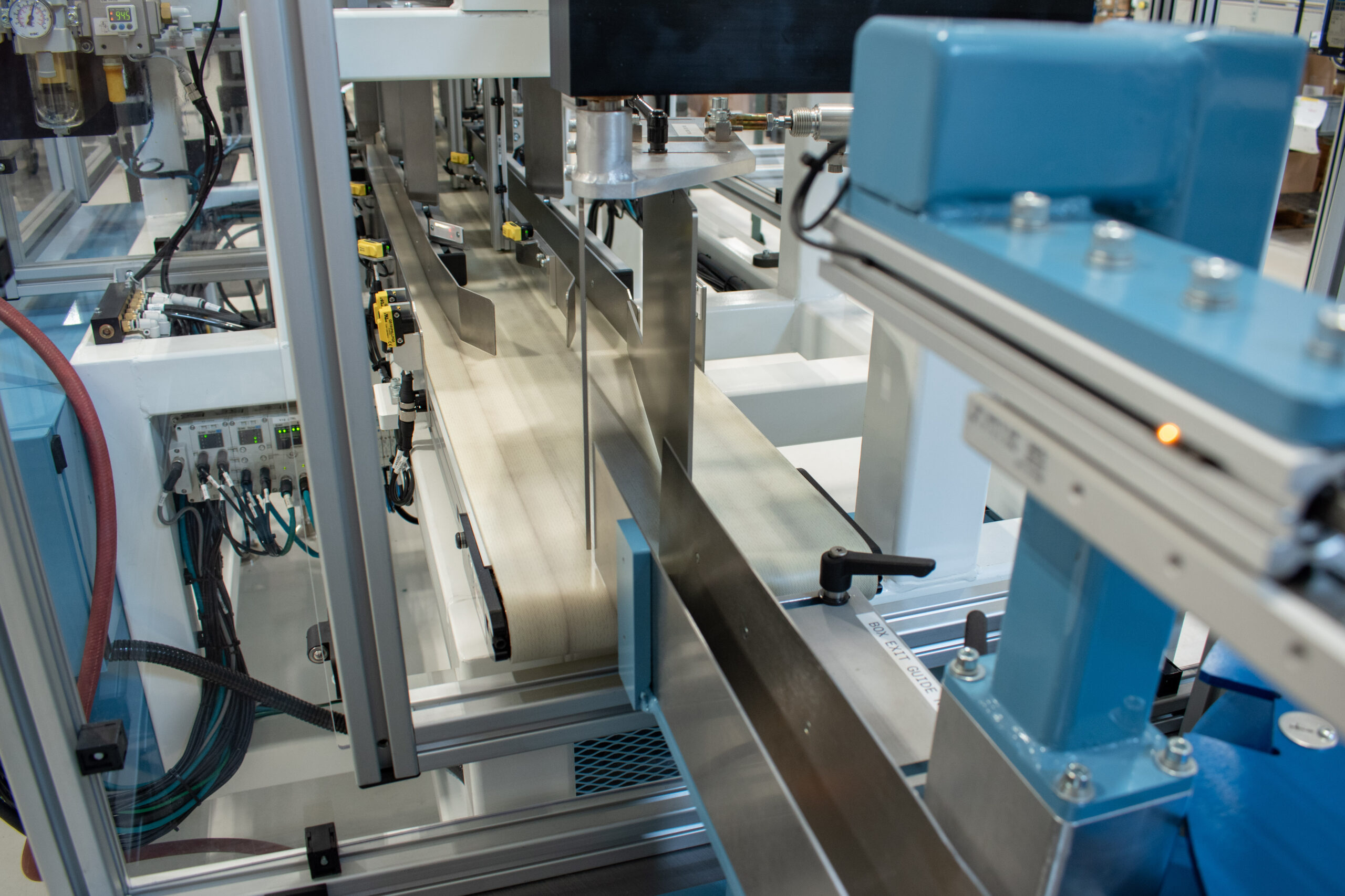 Custom pneumatic box diverter to sort cartons on a conveyor