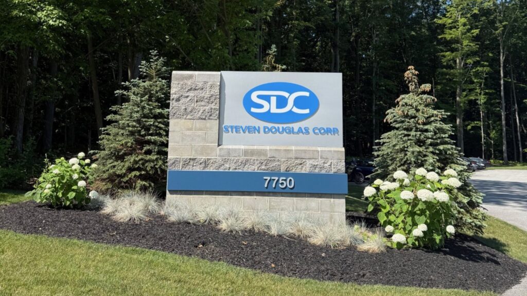SDC sign in blue surrounded by flowers and clean landscaping. 