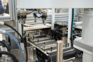 Robot getting ready to place coiled medical tubing on a conveyor