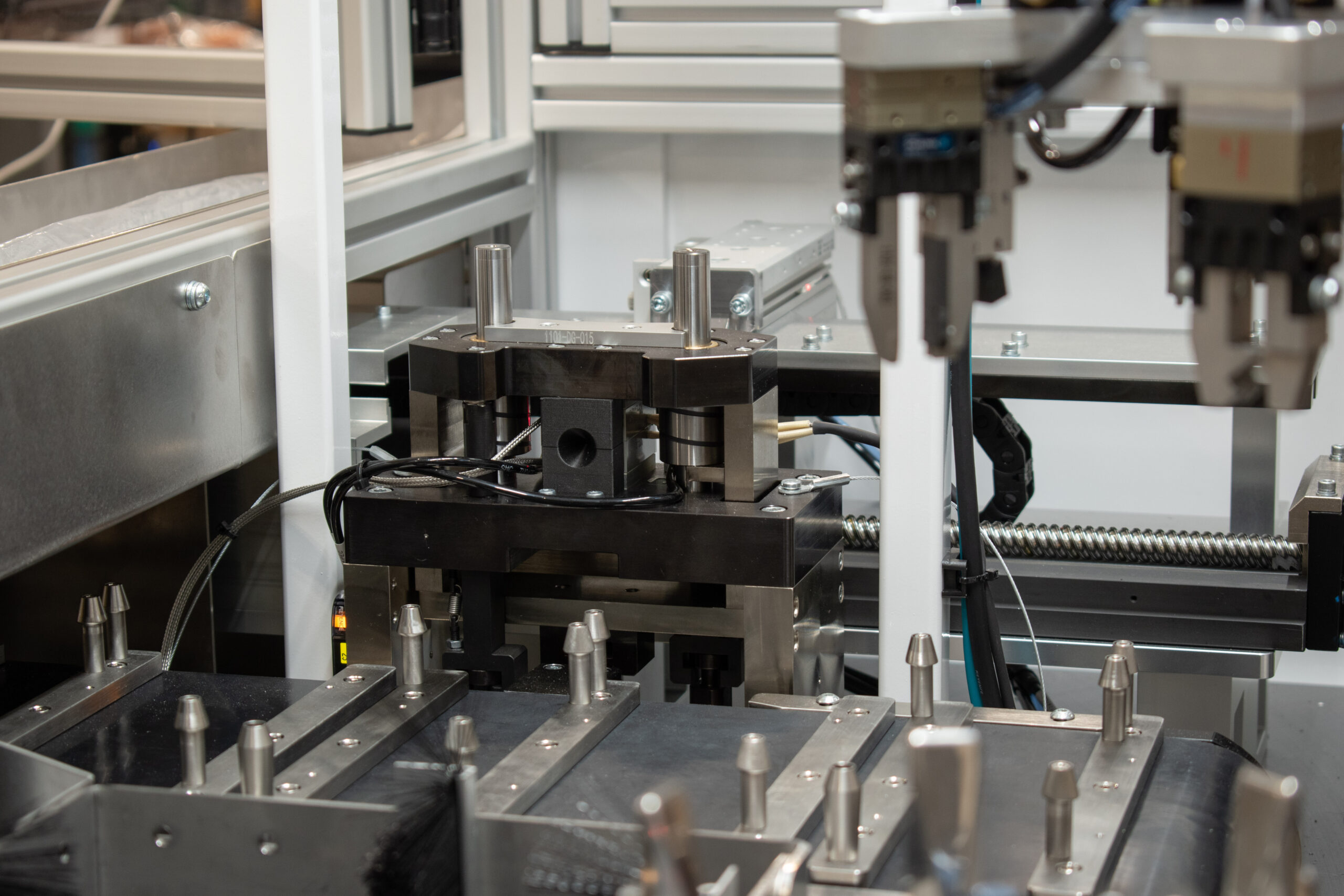 Heat stake press above an unload conveyor for coiled medical tubes