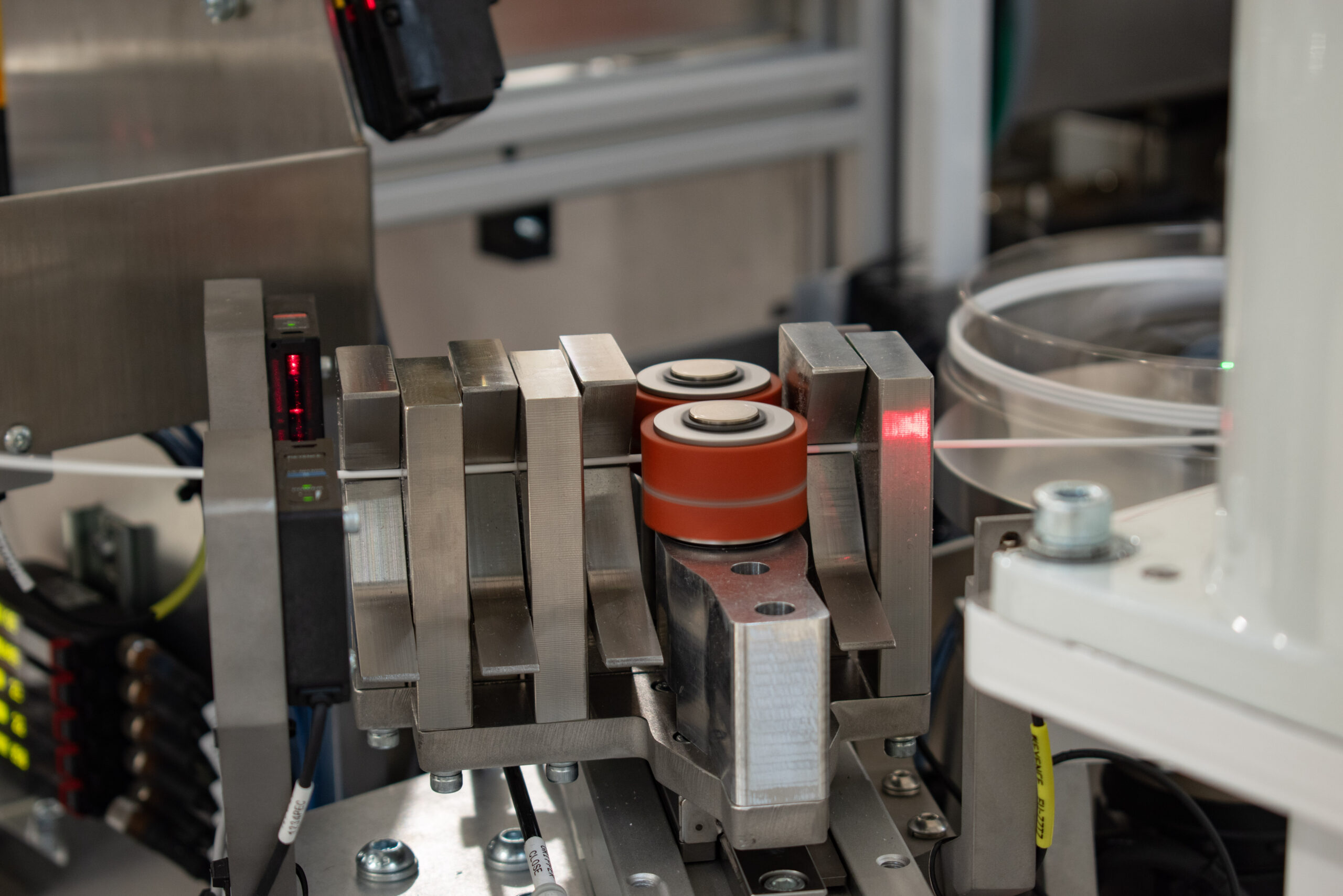 Medical tubing being fed through a tensioner and custom tooling