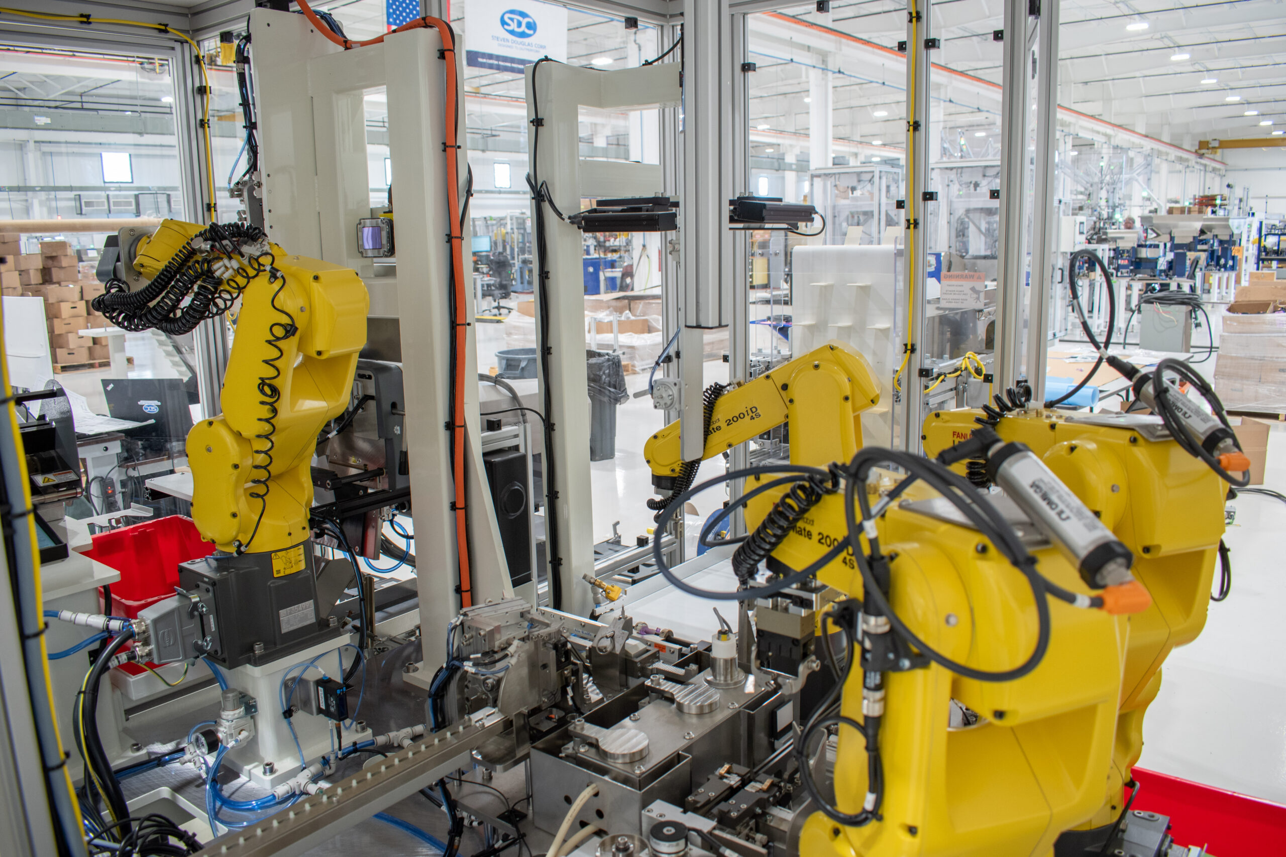 All four FANUC 6-axis robots on a custom automated medical device assembly machine