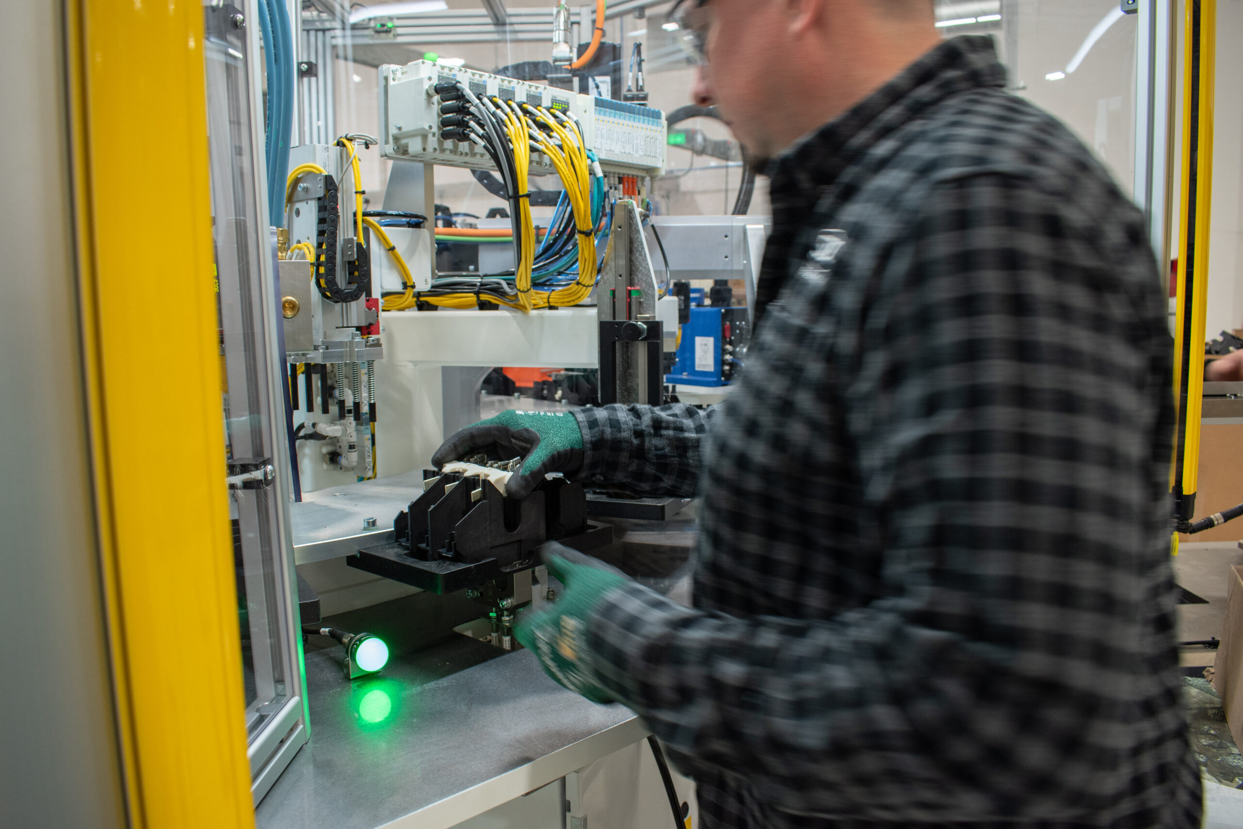 Semi-automated section of a custom machine with an operator loading a part into a nest on an SDC Indexing Ring